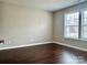 This bedroom has a neutral color palette, wood flooring, and a window with natural light at 7306 Fox Point Dr, Charlotte, NC 28269