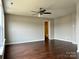 This bedroom has a ceiling fan, wood flooring, and a door leading to another room at 7306 Fox Point Dr, Charlotte, NC 28269