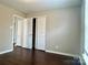 Bedroom with a set of closet doors and dark, wood-look floors at 7306 Fox Point Dr, Charlotte, NC 28269