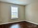 Bedroom with wood-look flooring and a large window for natural light at 7306 Fox Point Dr, Charlotte, NC 28269