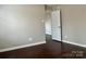 This bedroom has a neutral color palette, wood flooring, and a door leading to another room at 7306 Fox Point Dr, Charlotte, NC 28269
