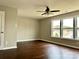 This bedroom has a ceiling fan, wood flooring, and three windows with outside views at 7306 Fox Point Dr, Charlotte, NC 28269