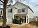 Charming two-story home featuring stone accents, an attached one-car garage, and a cozy front porch at 7306 Fox Point Dr, Charlotte, NC 28269