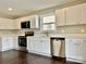 Modern kitchen featuring new white cabinets, stainless steel appliances, and hardwood floors at 7306 Fox Point Dr, Charlotte, NC 28269