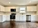 Bright kitchen showcasing white cabinets, stainless steel appliances, and wood-look flooring at 7306 Fox Point Dr, Charlotte, NC 28269