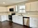 Modern kitchen featuring new white cabinets, stainless steel appliances, and hardwood floors at 7306 Fox Point Dr, Charlotte, NC 28269