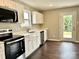 Well-lit kitchen featuring white cabinets, stainless steel appliances, and dark wood-look flooring at 7306 Fox Point Dr, Charlotte, NC 28269