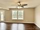 Bright living area featuring hardwood floors, a ceiling fan, and large windows at 7306 Fox Point Dr, Charlotte, NC 28269