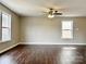 Bright living area featuring hardwood floors, a ceiling fan, and large windows at 7306 Fox Point Dr, Charlotte, NC 28269