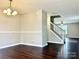 Spacious living room featuring a chandelier, hardwood floors, and a staircase to the upper level at 7306 Fox Point Dr, Charlotte, NC 28269