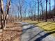 Gravel driveway leads through a wooded area, offering privacy at 8015 Sullivan Dr # 3 And 2, Charlotte, NC 28215