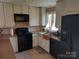 This is a well-equipped kitchen with black appliances and stone countertops with tile flooring at 8015 Sullivan Dr # 3 And 2, Charlotte, NC 28215