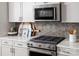 Close up of a modern kitchen stove, backsplash and countertop at 9416 Munsing Dr # 151, Charlotte, NC 28269