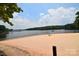 Sandy beach area with serene lake views, perfect for relaxing by the water at 109 Hummingbird Cir, New London, NC 28127
