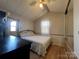 This bedroom features a queen bed, a ceiling fan, and lots of natural light with direct access to the yard at 109 Hummingbird Cir, New London, NC 28127