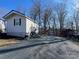 A single-story house with gray siding, gravel driveway, a storage shed, and a red car nearby at 109 Hummingbird Cir, New London, NC 28127