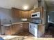 Charming kitchen showcasing wooden cabinetry, white appliances, and neutral countertops at 109 Hummingbird Cir, New London, NC 28127