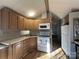 Bright kitchen featuring wood cabinets, white appliances, and laminate flooring at 109 Hummingbird Cir, New London, NC 28127