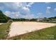 Outdoor sand volleyball court with nearby playground under a blue sky, great for community fun at 109 Hummingbird Cir, New London, NC 28127