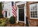 Close-up of a townhouse entryway with brick facade, American flag, and a decorative door wreath at 11406 Potters Row, Cornelius, NC 28031