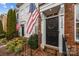 Inviting townhouse entrance featuring brick steps, black door with wreath, and patriotic American flags at 11406 Potters Row, Cornelius, NC 28031