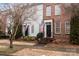 Townhouse facades showcasing brick and siding, American flags, and inviting entrances at 11406 Potters Row, Cornelius, NC 28031