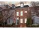A townhouse exhibits brick facade, dormer windows, and a welcoming front entrance under a sunset sky at 11406 Potters Row, Cornelius, NC 28031