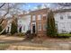 Charming townhouses with a mix of brick and white siding, American flags, and well-manicured landscaping at 11406 Potters Row, Cornelius, NC 28031
