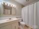 Bathroom features a vanity with a sink, mirror with lighting and a shower with a white curtain at 1200 Berkshire Dr, Kannapolis, NC 28081