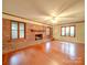 Bright living room featuring hardwood floors, a brick fireplace, and large windows at 1200 Berkshire Dr, Kannapolis, NC 28081
