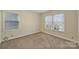 This bright, carpeted bedroom features two big windows and neutral paint at 12724 Cliffcreek Dr, Huntersville, NC 28078