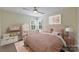 Pink themed bedroom features a large window, ceiling fan, and stylish decor at 12724 Cliffcreek Dr, Huntersville, NC 28078