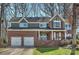 Charming two-story brick home with an attached two-car garage and well-manicured front yard at 12724 Cliffcreek Dr, Huntersville, NC 28078