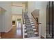 Bright foyer featuring hardwood floors, staircase with carpet runner, and views into the living spaces at 12724 Cliffcreek Dr, Huntersville, NC 28078