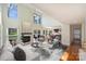 Open-concept living room with fireplace, vaulted ceiling, large windows, and wood floors at 12724 Cliffcreek Dr, Huntersville, NC 28078