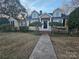 Charming yellow home with a walkway leading to a covered front porch with two dormer windows above at 1637 Longfellow St, Charlotte, NC 28205