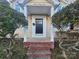 Covered front porch with brick steps and a black front door flanked by two small, round trees at 1637 Longfellow St, Charlotte, NC 28205