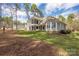 Large backyard with a manicured lawn, mature trees and a spacious patio area at 1718 Brawley School Rd, Mooresville, NC 28117