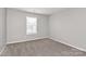 Bright bedroom features a large window and neutral carpet at 1765 Holliford Ct, Charlotte, NC 28215