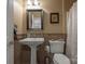 Elegant bathroom with a pedestal sink, tiled walls, and neutral color palette at 1910 Colony Line Ct, Charlotte, NC 28210