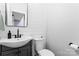 Well-lit half bathroom featuring a modern sink, toilet, and shiplap walls at 1921 Kenilworth Ave, Charlotte, NC 28203