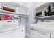 Laundry room featuring front-load washer and dryer units, with open shelving for storage of laundry supplies at 1921 Kenilworth Ave, Charlotte, NC 28203