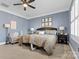 Inviting bedroom with a cozy armchair, ceiling fan, and ample natural light at 243 Crownsgate Ct, Charlotte, NC 28207