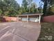 Detached two car garage with an elongated driveway and fenced perimeter at 2721 Dora Dr, Charlotte, NC 28215