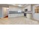 Modern kitchen featuring white cabinetry, stainless steel appliances, and tile floors at 2721 Dora Dr, Charlotte, NC 28215