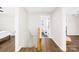 Hallway with wood floors leads to a bathroom with black tiled floors at 2927 Forest Hills Cir, Rock Hill, SC 29732