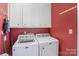 Functional laundry room with modern washer and dryer, storage cabinets, and bright lighting at 2968 Robinwood Rd, Gastonia, NC 28054