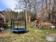 Large backyard with a trampoline, playset, garden bed, and plenty of space for outdoor activities at 2992 Greenleaf Rd, Clover, SC 29710