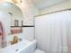 Well-lit bathroom with white fixtures, charming details, and a shower with a curtain at 4310 Randolph Rd, Charlotte, NC 28211