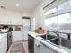 Functional kitchen with a large window, white cabinets, and a stacked washer and dryer at 4310 Randolph Rd, Charlotte, NC 28211